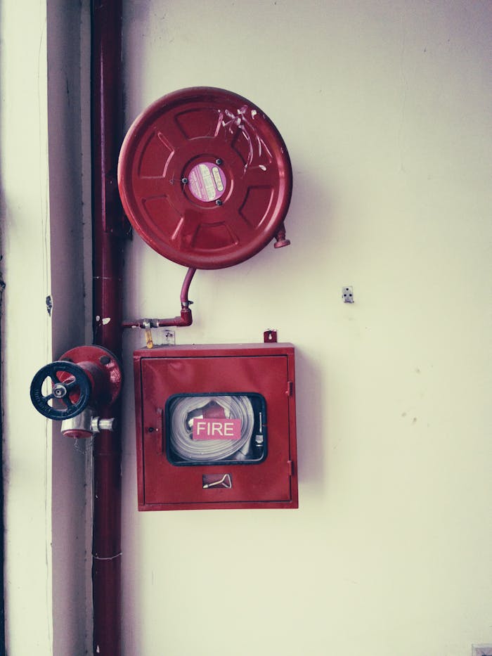 Red fire safety equipment on a white wall, essential for emergencies.